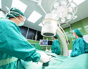three surgeons are doing operation to a patient in a surgery room